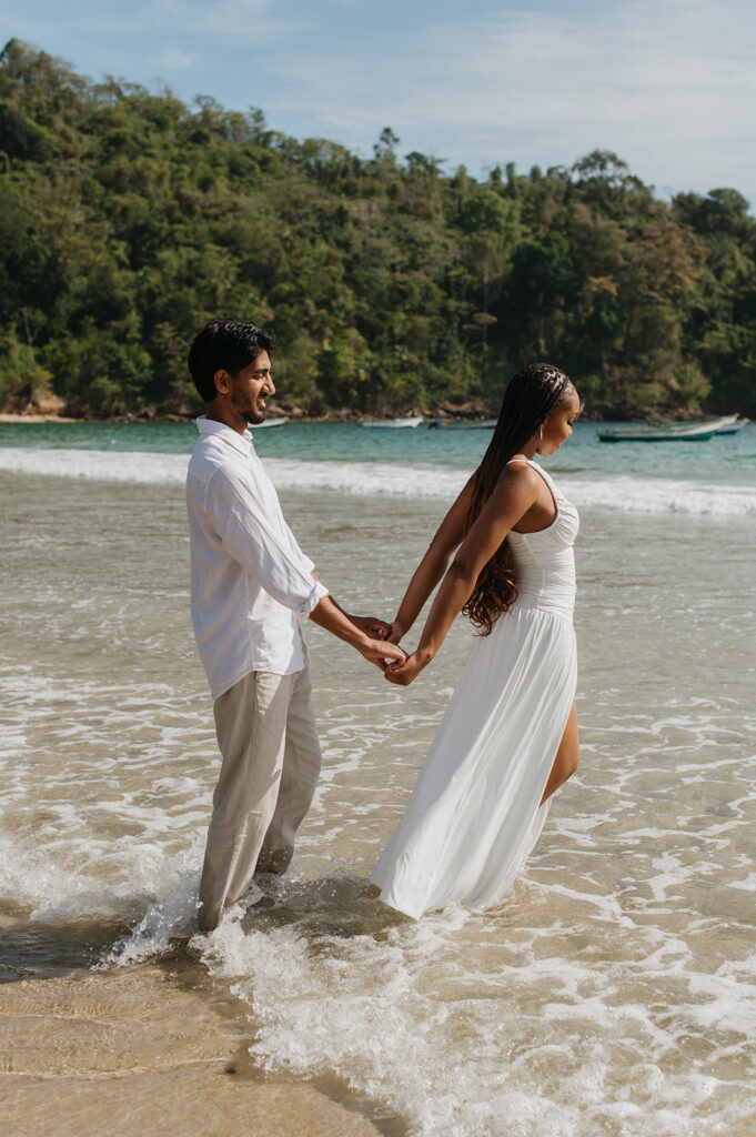 A playful moment as the couple poses on a quiet morning at Maracas Beach
