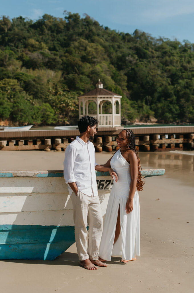 Brandon and Qetsia laughing together in the sand with palm trees in the background
