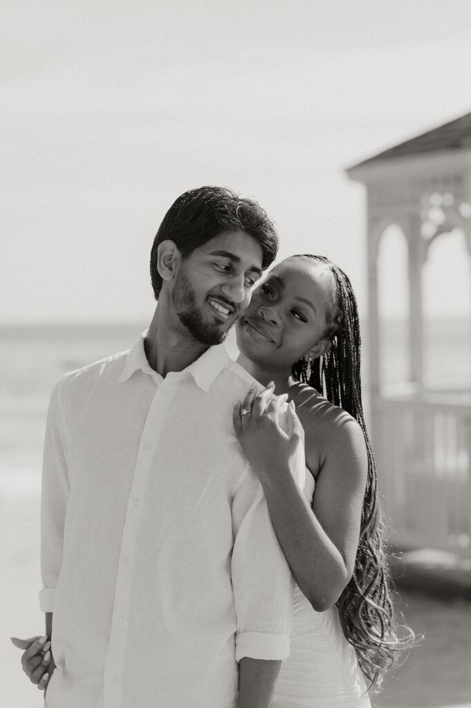 A couple walking hand in hand along the shoreline at Maracas Beach during their engagement session
