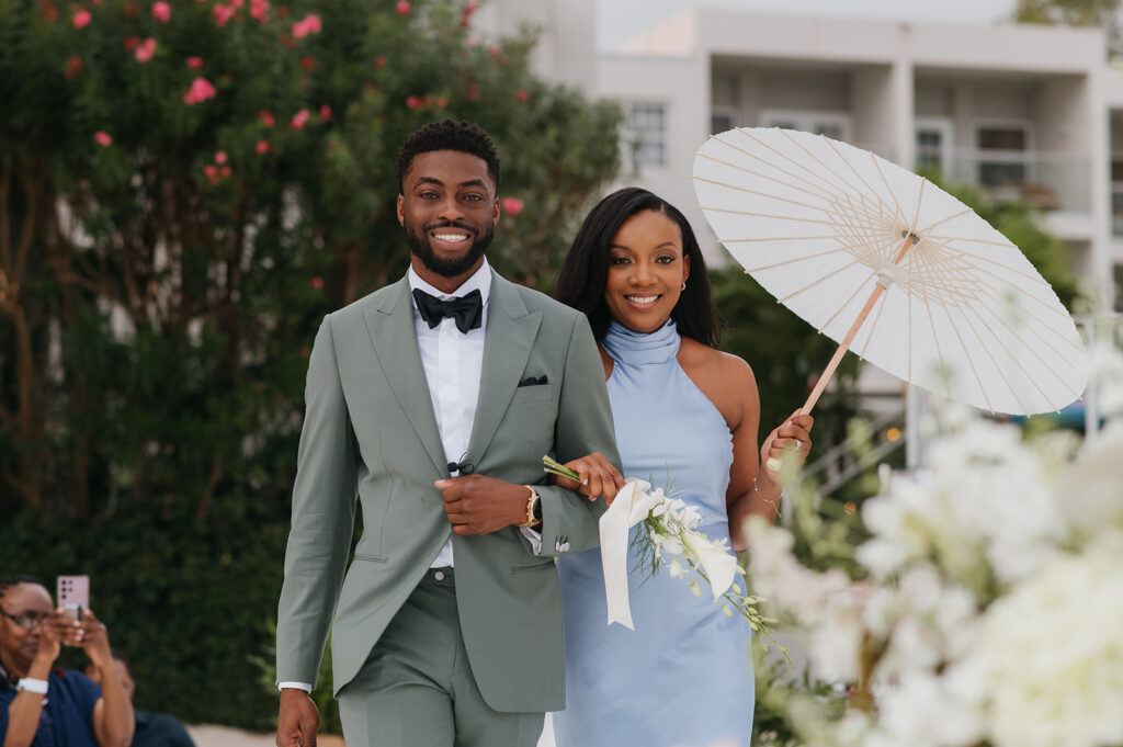 Wedding ceremony setup on the beach with tropical floral decor and ocean views
