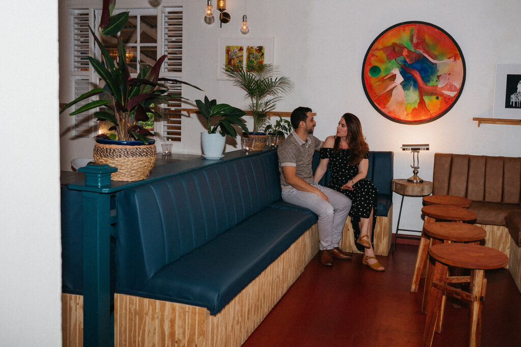 Couple enjoying cocktails together during their engagement session on Ariapita Avenue

