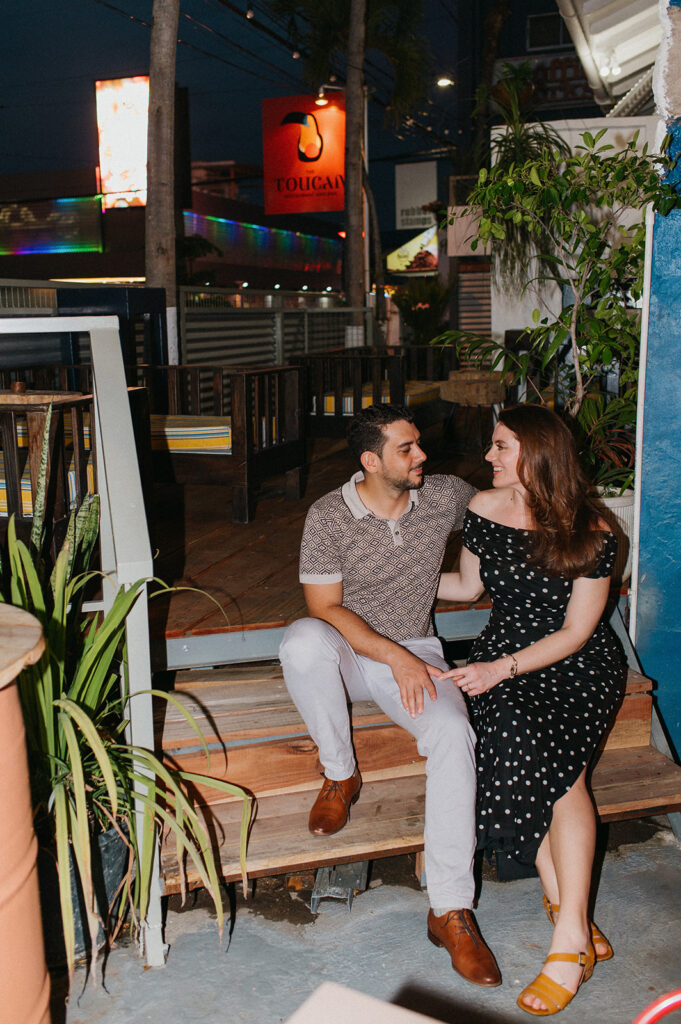 Engagement photo of a couple laughing together on a night out
