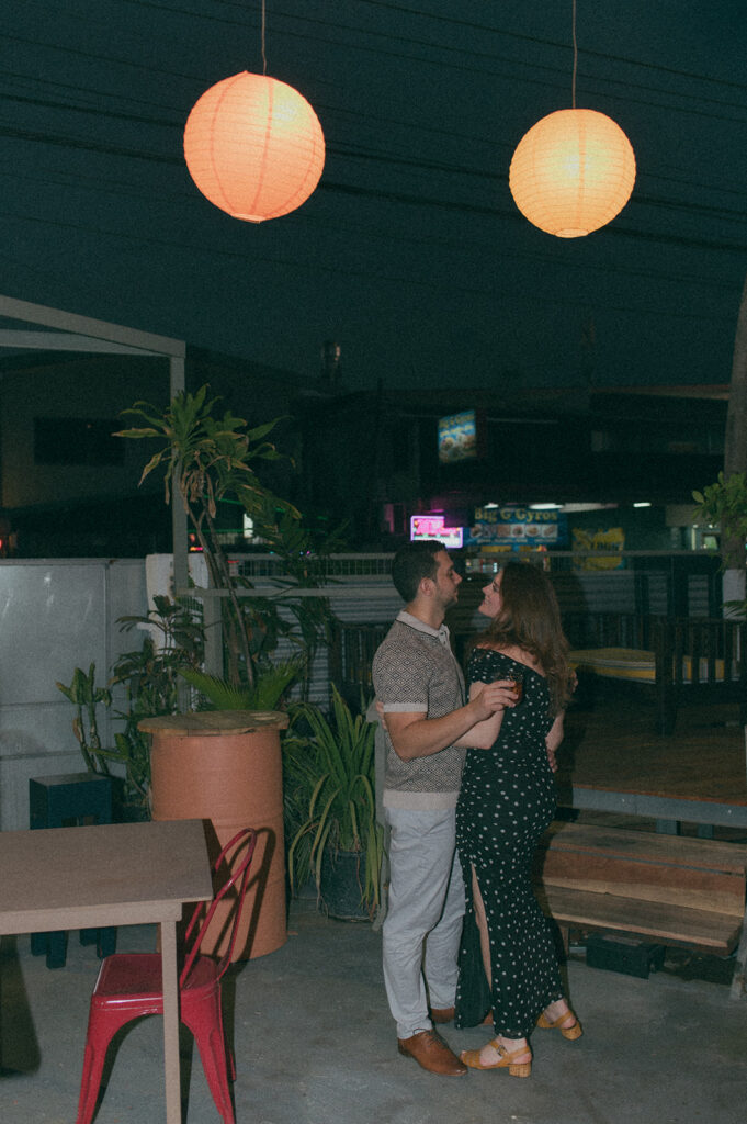 Couple enjoying cocktails together during their engagement session on Ariapita Avenue

