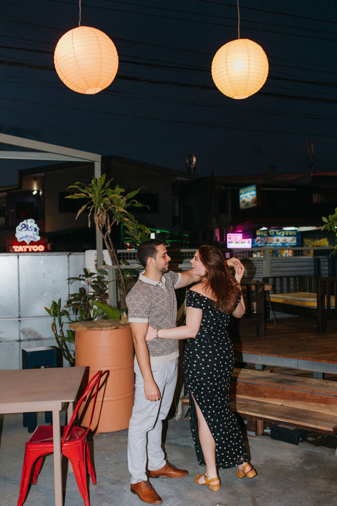 Candid flash photo of a couple dancing at a bar

