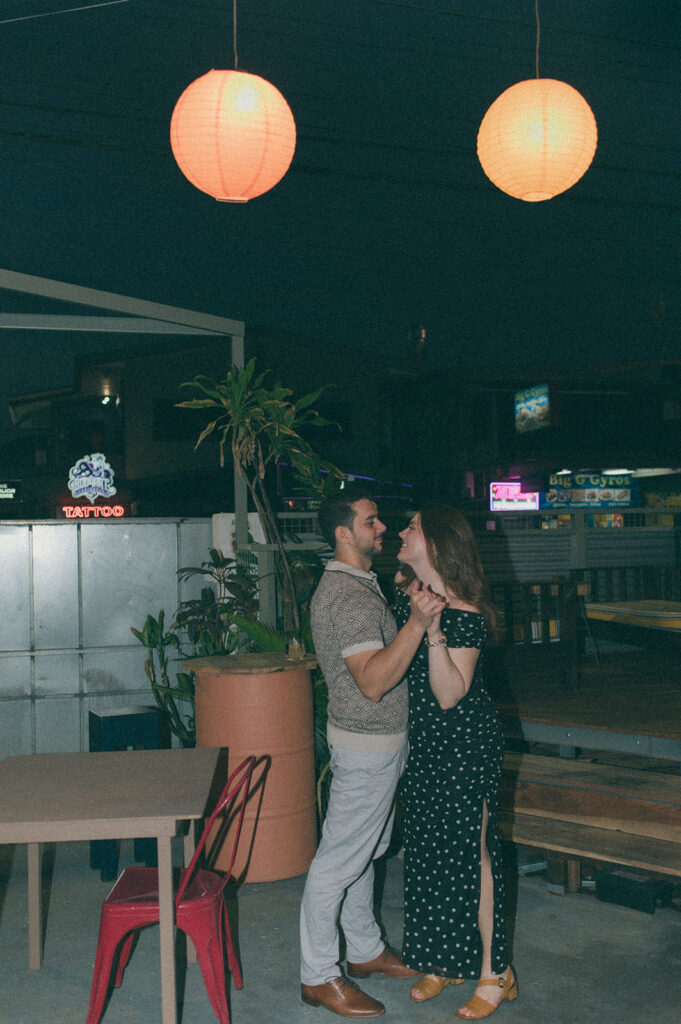 Candid flash photo of a couple dancing at a bar
