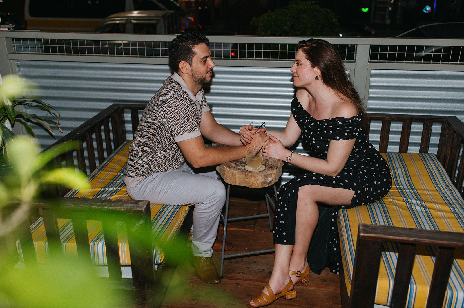 Couple enjoying cocktails together during their engagement session on Ariapita Avenue