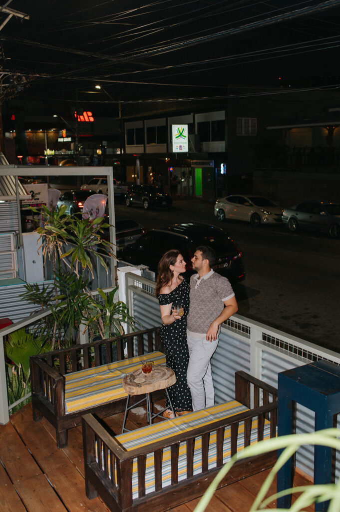 Couple enjoying cocktails together during their engagement session on Ariapita Avenue
