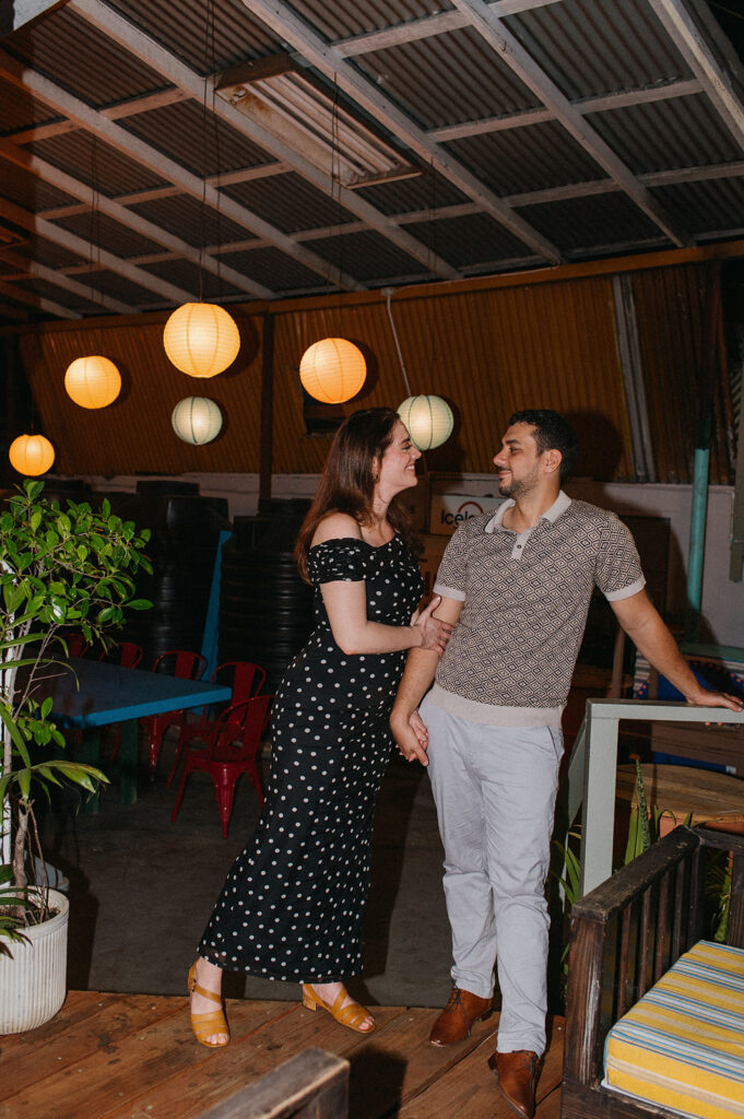 Couple enjoying cocktails together during their engagement session on Ariapita Avenue
