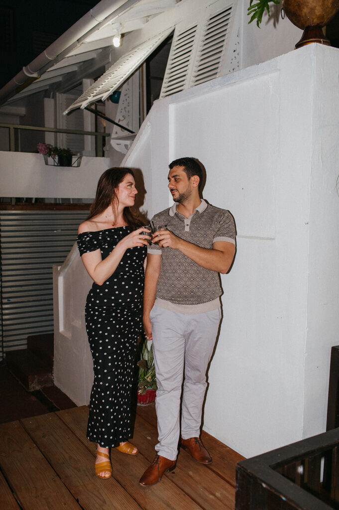 Couple enjoying cocktails together during their engagement session on Ariapita Avenue
