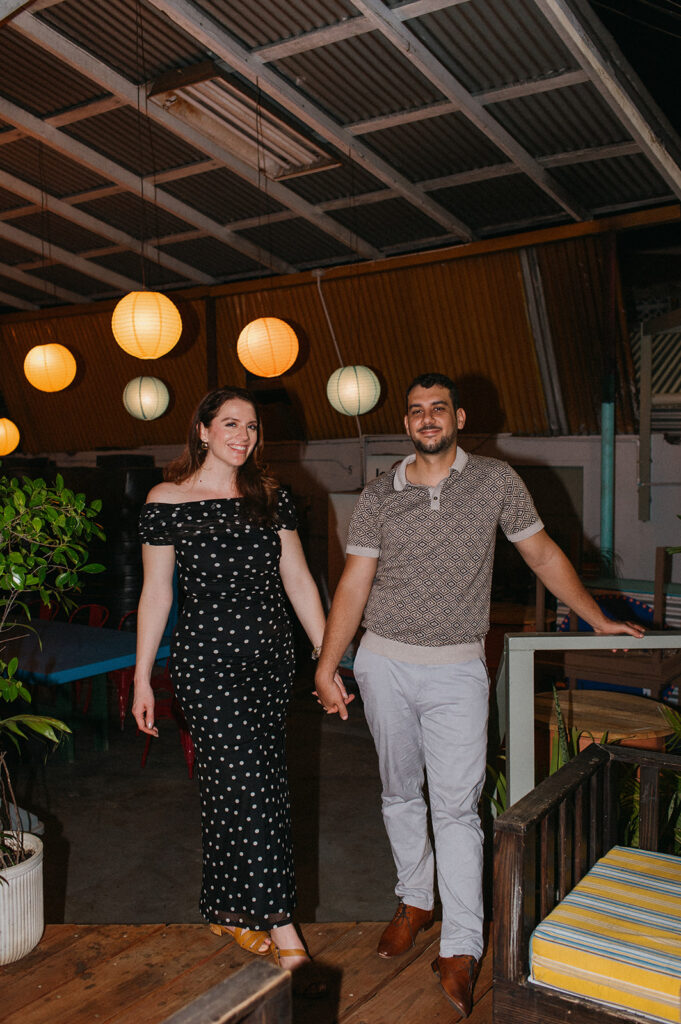 Couple enjoying cocktails together during their engagement session on Ariapita Avenue
