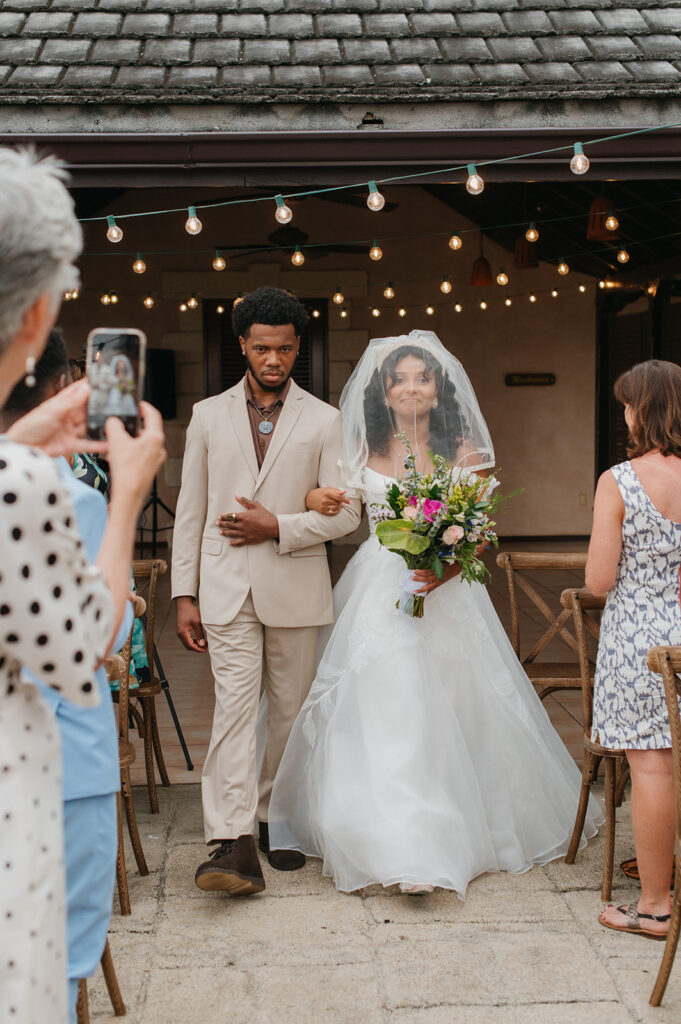 Intimate wedding ceremony with family and friends gathered outdoors
