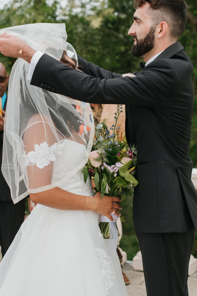 Intimate wedding ceremony with family and friends gathered outdoors
