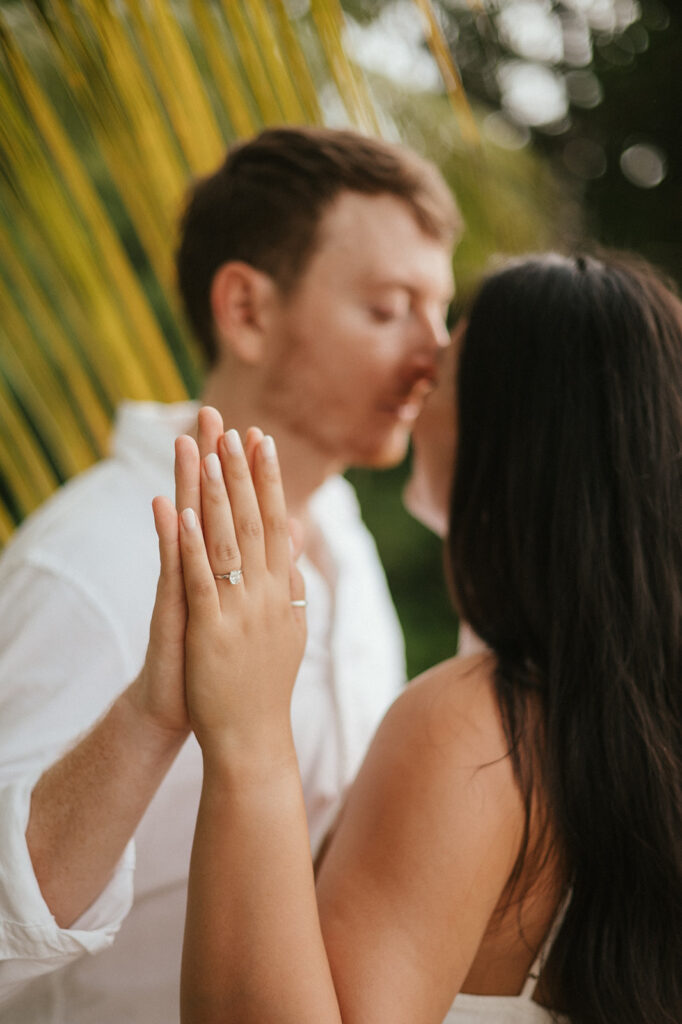 Newly engaged couple laughing during a celebration on the sand at Las Cuevas Beach.
