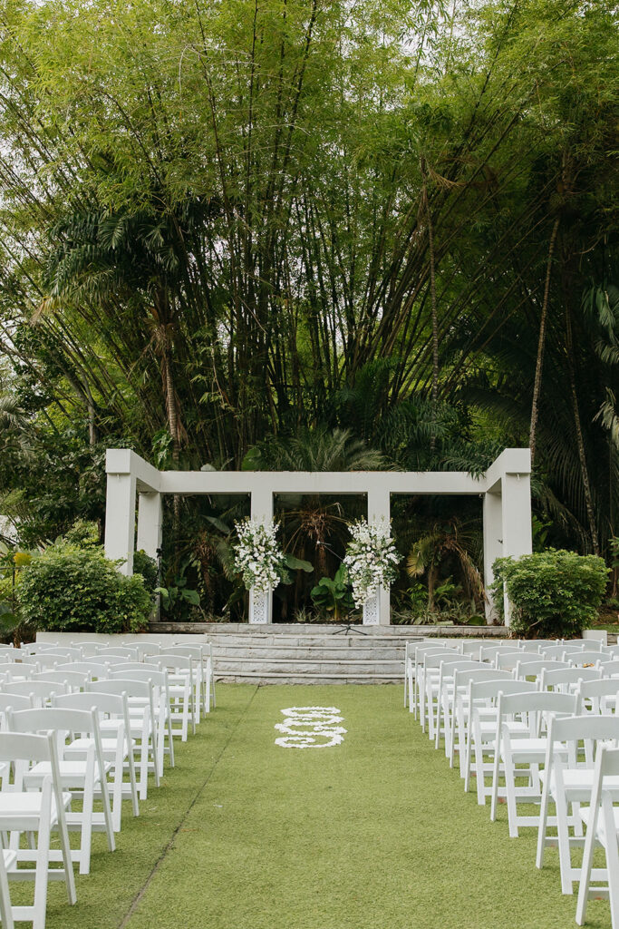 Romantic outdoor wedding ceremony surrounded by greenery.
