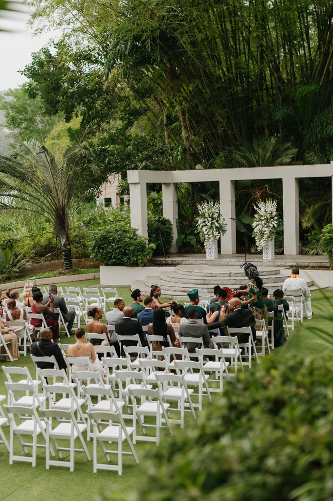 Romantic outdoor wedding ceremony surrounded by greenery.
