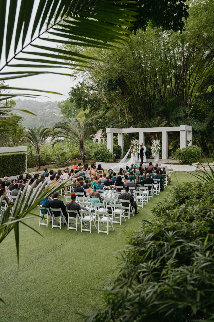 Romantic outdoor wedding ceremony surrounded by greenery.
