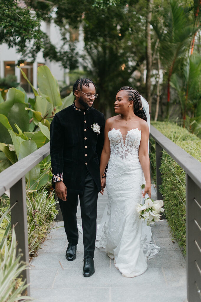 Couple walking hand in hand during portraits in the lush grounds.
