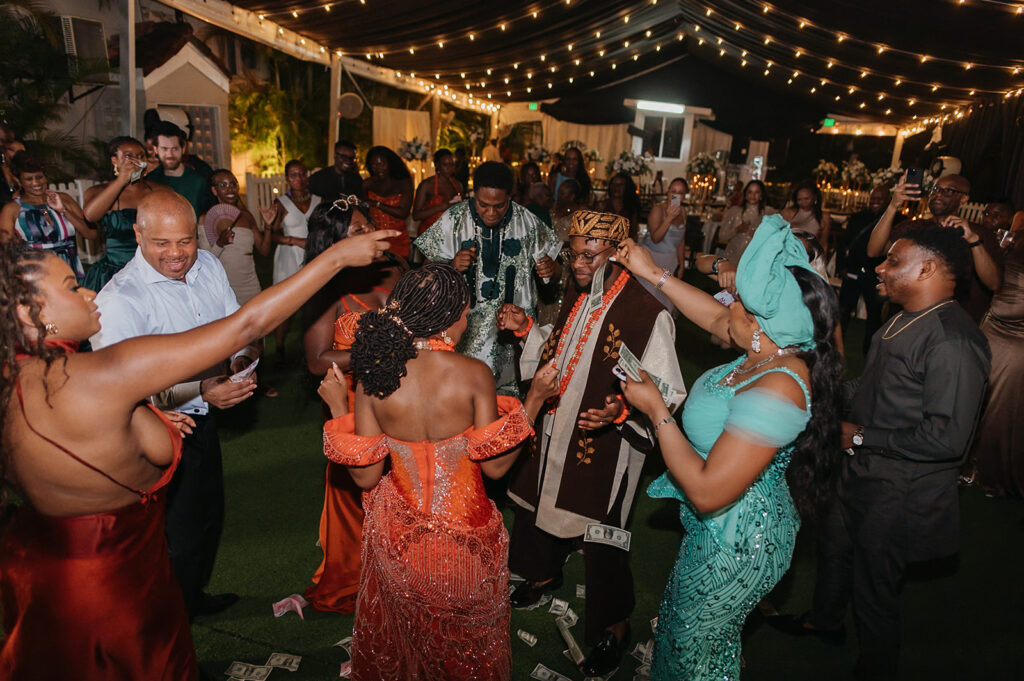 Bride and groom in traditional Nigerian attire dancing.
