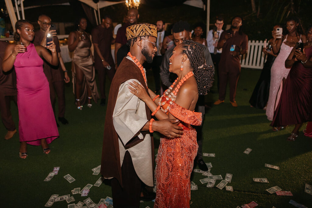 Bride and groom in traditional Nigerian attire dancing.
